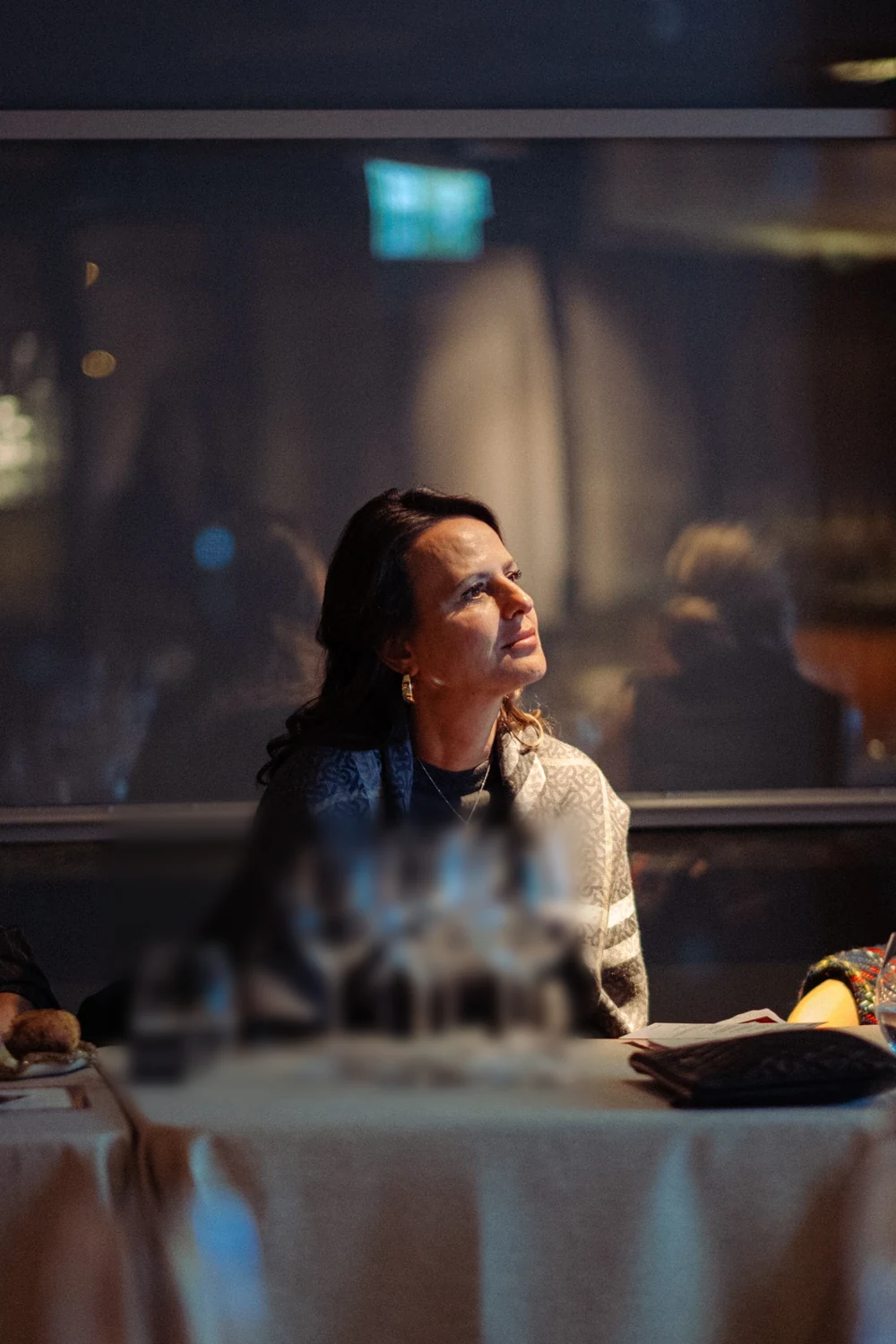 A guest looking up across the room from her seat at the table