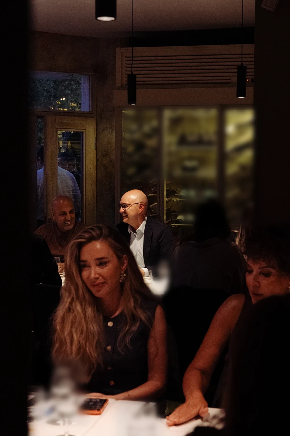 Two guests at the table in front of a lit cellar