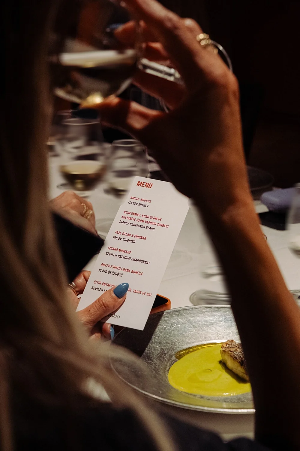 A guest holding the evening's menu card